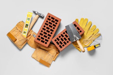 İnşaat kemerine ve beyaz arkaplanda farklı araçlara sahip tuğlalar