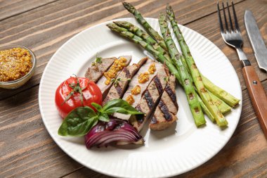 Sebzeli ızgara biftek ve ahşap arka planda Dijon hardalı.