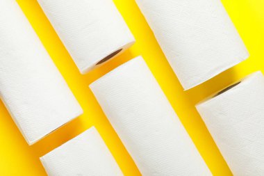 Sarı arka planda kağıt havlu ruloları