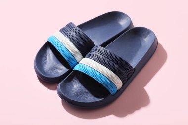 Pembe arka planda şık parmak arası terlikler