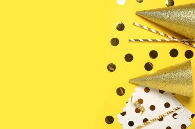 Sarı arka planda pipetli ve konfetili altın koni parti şapkaları