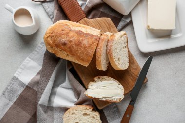 Tereyağlı dilimlenmiş ekmek ve gri grunge arka planda bir sürahi krema.