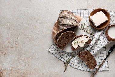 Tereyağlı dilimlenmiş ekmek, kekik ve grunge arka planda bir sürahi süt