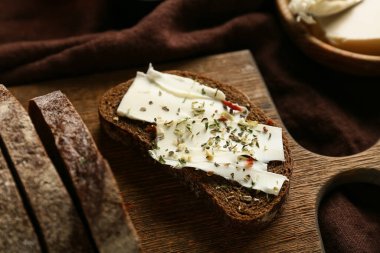 Tahtada tereyağlı ve otlu taze ekmek dilimleri, yakın plan.
