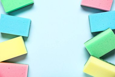 Mavi arkaplanda renkli temizlik süngerlerinden yapılmış çerçeve