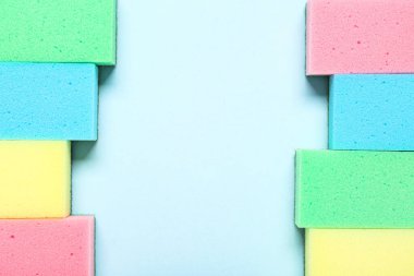 Mavi arkaplanda renkli temizlik süngerlerinden yapılmış çerçeve