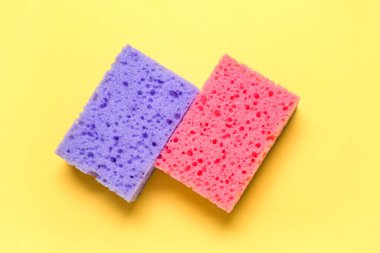 Sarı arkaplanda süngerler temizleniyor