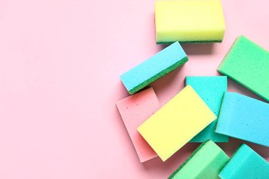 Pembe arka planda birçok renkli temizlik süngeri