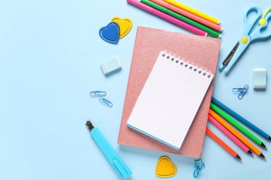 Mavi arkaplanda kırtasiye malzemesi olan defterler