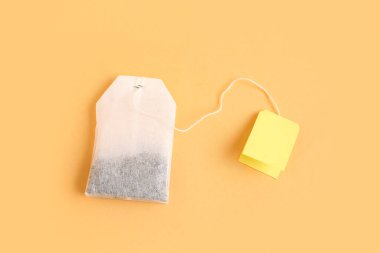 Turuncu arka planda sarı etiketli çay poşeti