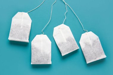 Turkuaz arka planda çay poşetleri