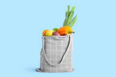 Sebzeli bez çanta ve mavi arka planda meyveler.