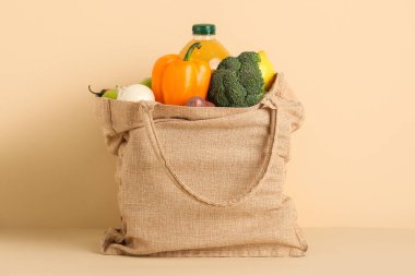 Bej arka planda sebze ve meyve suyu dolu bez poşet.