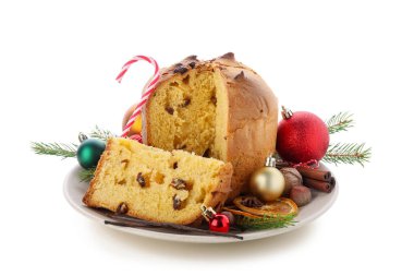 Kesik Panettone tabağı, Noel topları, köknar dalları, fındık ve baharatlar beyaz arka planda