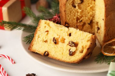 Açık arkaplanda kesilmiş Panettone ve köknar dalları ile plaka