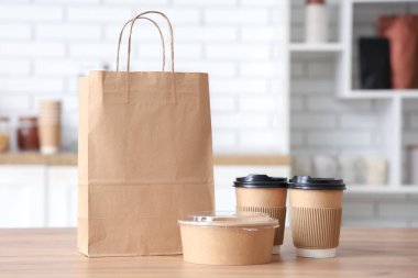 Kafede kahve fincanı ve konteynır dolu kağıt torba.