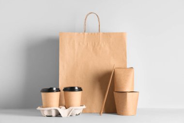 Kağıt torba, kaplar, kahve fincanları ve yemek çubukları beyaz arka planda