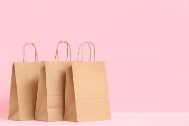 Pembe arka planda kağıt torbalar