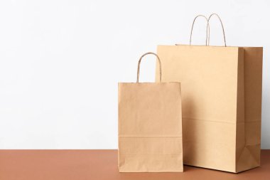 Kağıt torbalar beyaz duvara karşı kahverengi masada.