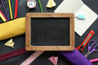 Siyah karatahtanın üzerinde not defteri ve tahtası olan farklı okul kırtasiyesi