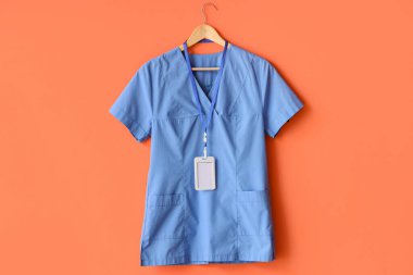 Rozeti turuncu arka planda asılı tıbbi üniforma