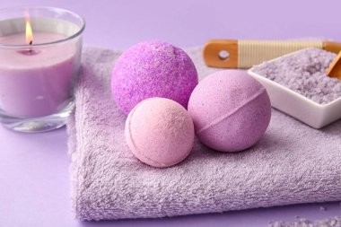 Havlu ve banyo bombalı kompozisyon eflatun arka planda, yakın plan