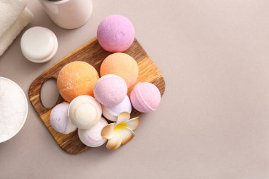 Ahşap tahtalı kompozisyon ve gri arka planda farklı banyo bombaları, yakın plan.