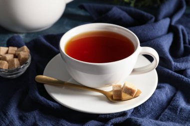 Arka plan olarak mavi peçete üzerine siyah çay fincanı ile kompozisyon, yakın plan