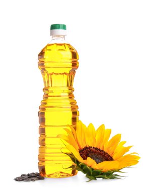 Ayçiçekli bir şişe yağ ve beyaz arka planda tohumlar.