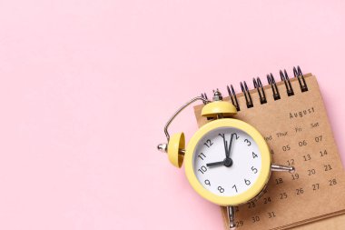 Pembe arkaplanda alarmlı saat takvimi