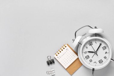 Gri arkaplanda alarm saati ve klasörleri olan takvim