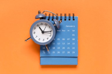 Turuncu arkaplanda alarmlı saat takvimi