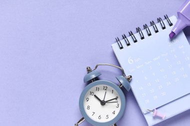Alarm saati, işaret ve mor arkaplan üzerindeki kağıt pin takvimi