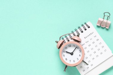 Alarm saati ve turkuaz arkaplan üzerindeki klasör klibine sahip takvim