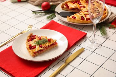 Lezzetli yaban mersini turtası, köknar ağacı dalları ve dekorla Noel yemeği için şık bir masa.