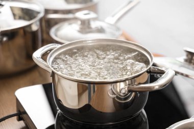 Mutfaktaki mini ocakta kaynar suyla pişirme kabı, yakın çekim.