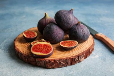 Ahşap tahta tahta, mavi arka planda taze incir.