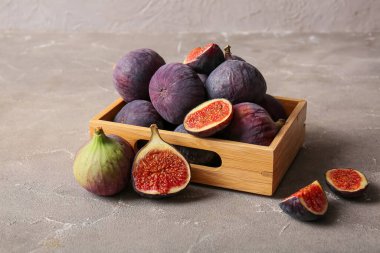 Gri arka planda taze incir bulunan ahşap kutu.