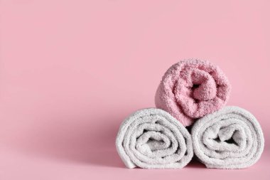 Pembe arka planda yumuşak havlular olan kompozisyon, yakın plan.