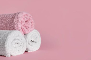 Pembe arka planda yumuşak havlular olan kompozisyon, yakın plan.