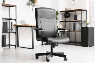 Odanın içinde siyah deri ofis koltuğu, yakın plan.