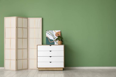 Yeşil duvarın yanındaki çekmeceler katlanır.