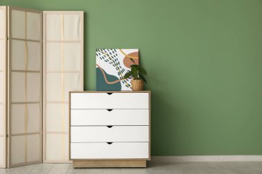 Yeşil duvarın yanındaki çekmeceler katlanır.