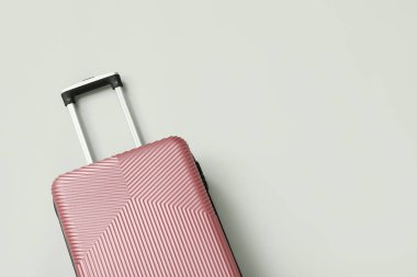 Beyaz arkaplanda pembe bavul, yakın plan.