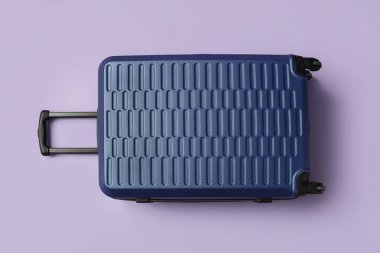 Eflatun arka planda mavi bavul