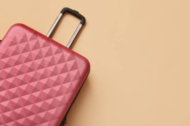 Bej arka planda pembe bavul, yakın plan.