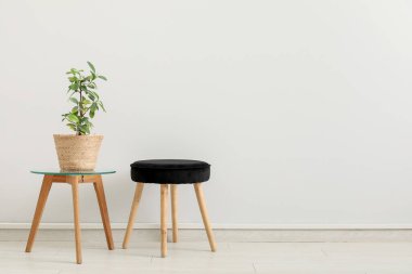 Kahve masası ve odanın iç tarafındaki beyaz duvarın yanındaki tabure.