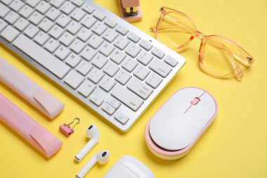 Sarı arkaplanda klavye, fare ve kırtasiye ile kompozisyon, yakın plan