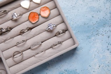 Mavi grunge arka planında şık mücevherlere sahip organizatör, yakın plan