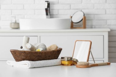 Masaj fırçası, havlu ve sepet. Banyo masasında bitki torbaları var.